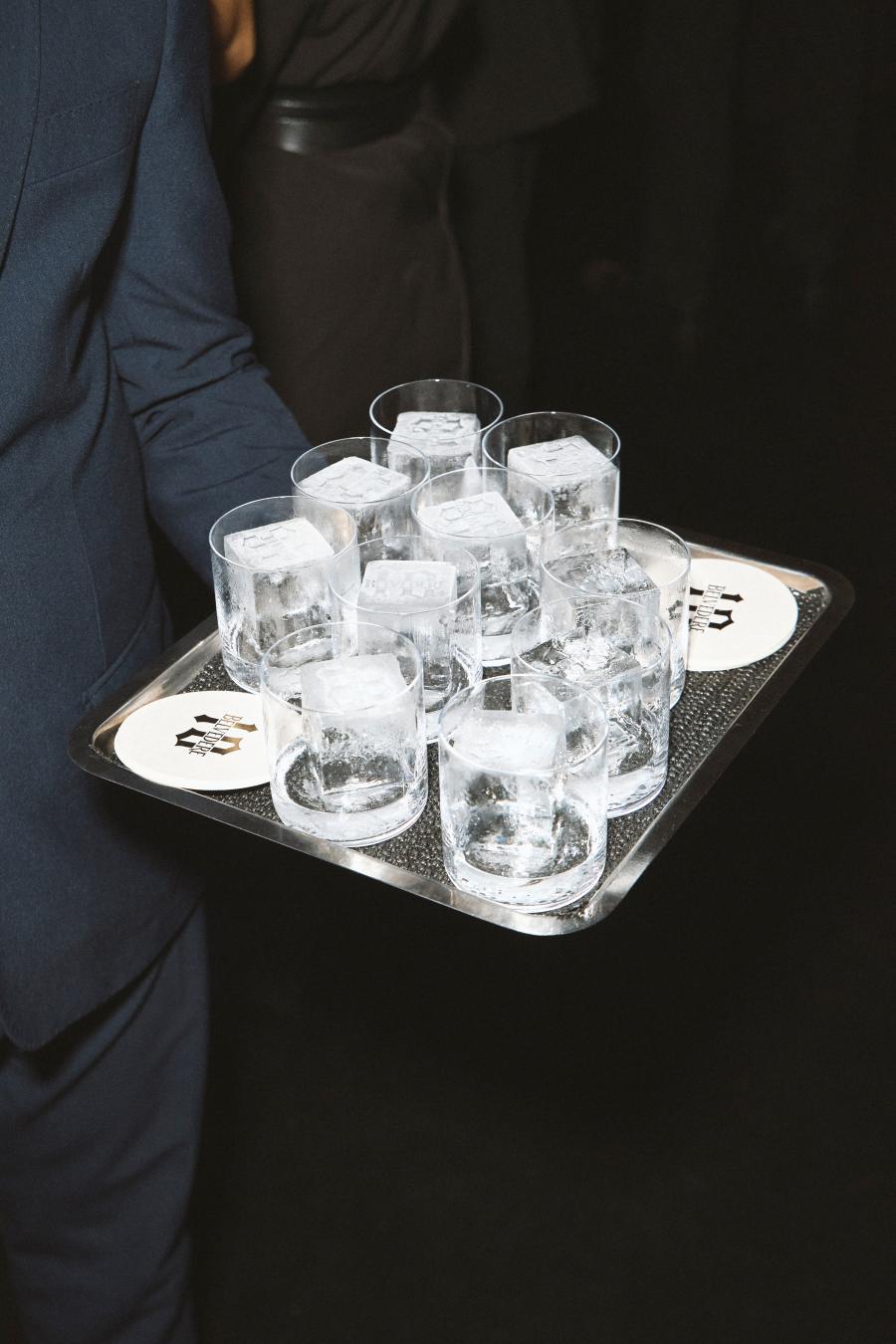 Waiter carrying a tray of Belvedere 10 glasses with engraved ice cubes