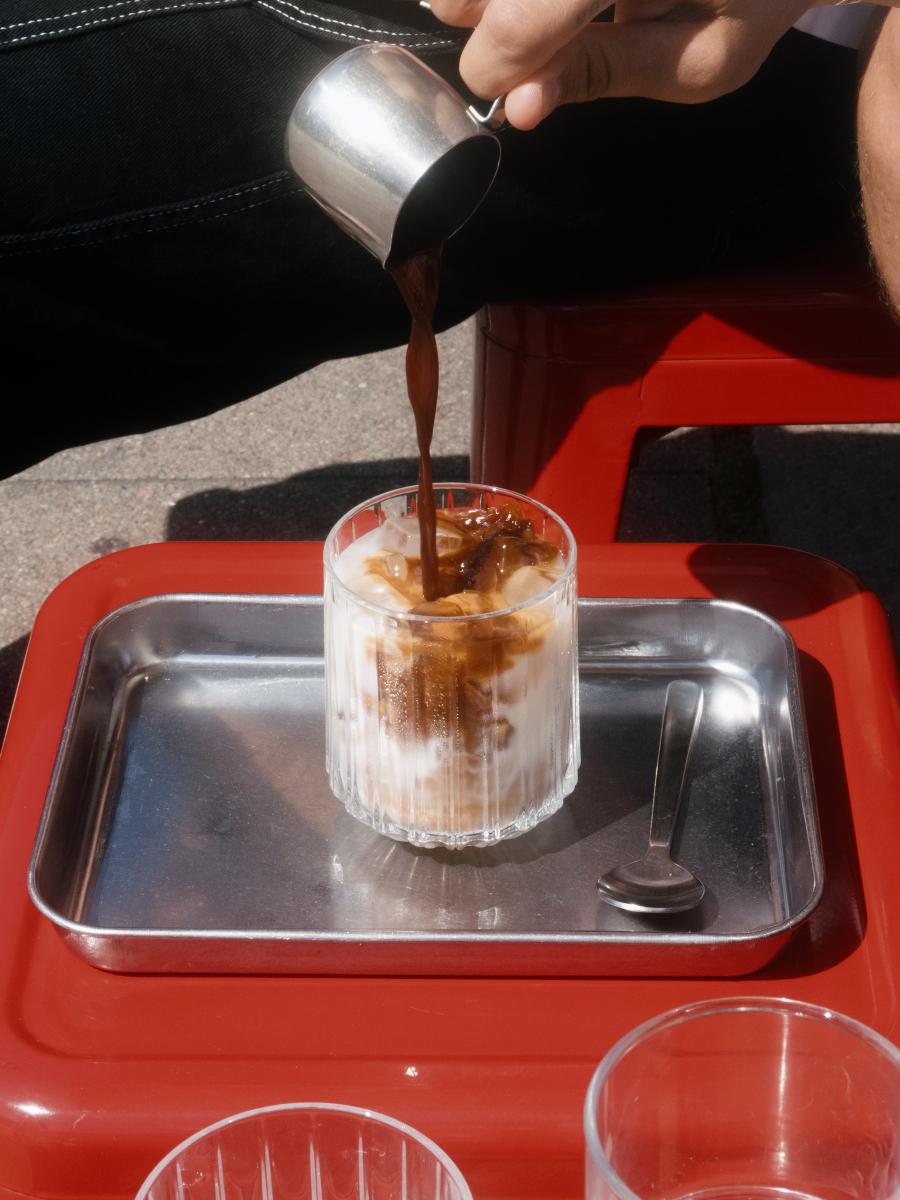 Belvedere Dirty Brew poured over ice in a glass on a red tray