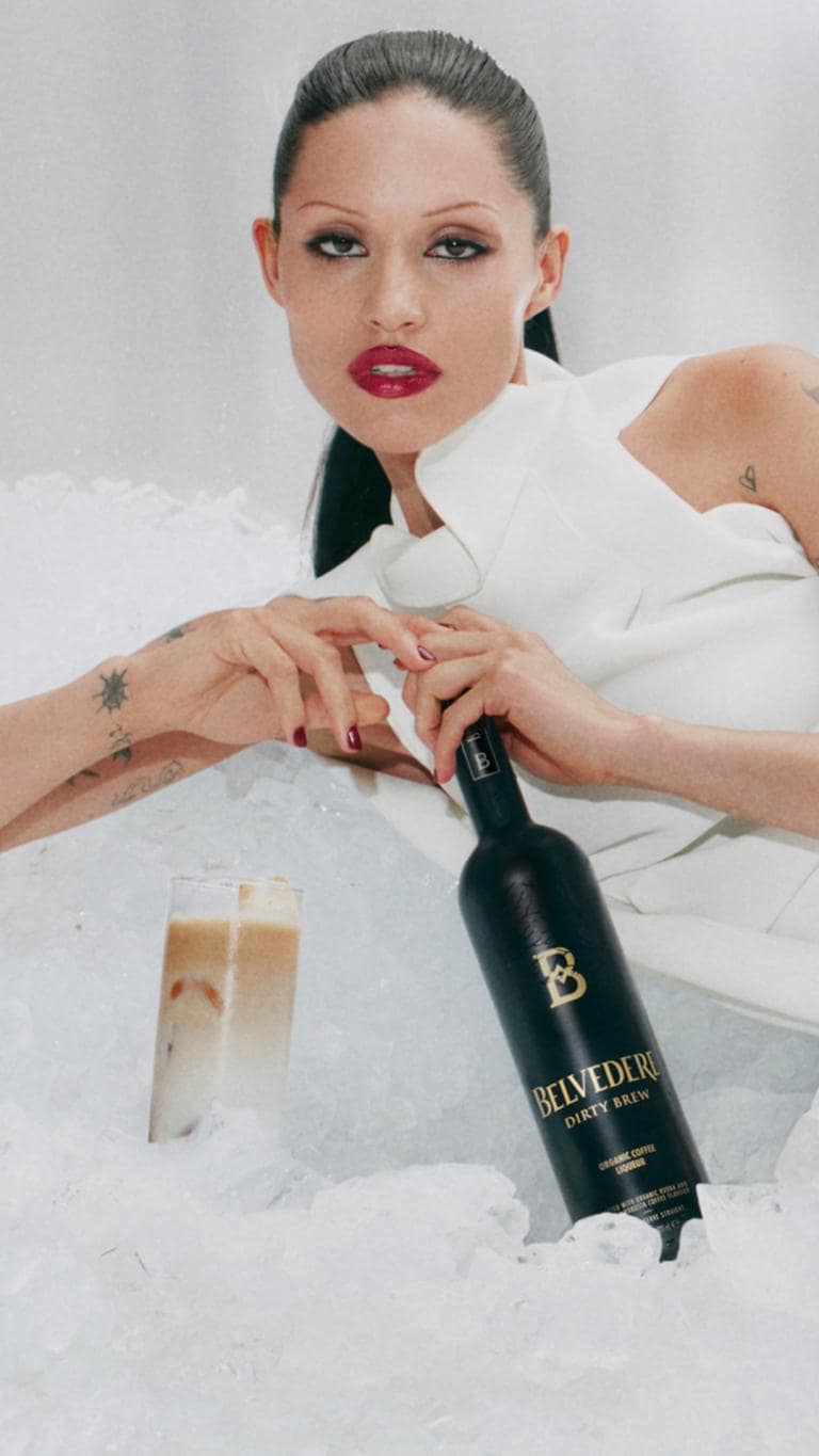 Gabbriette lying on ice with a bottle of Belvedere Dirty Brew