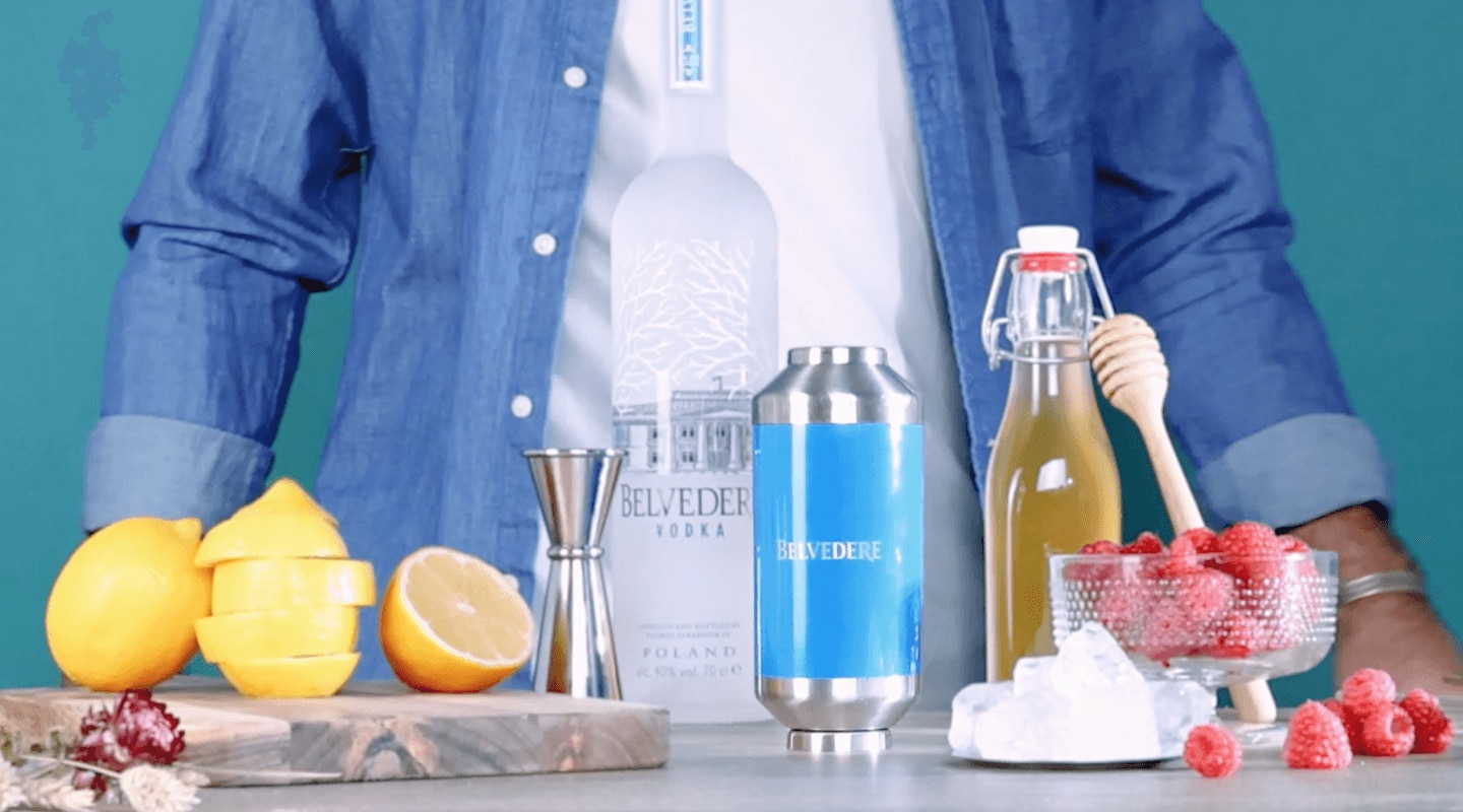 person standing in front of cocktail mixing ingredients and belvedere shaker
